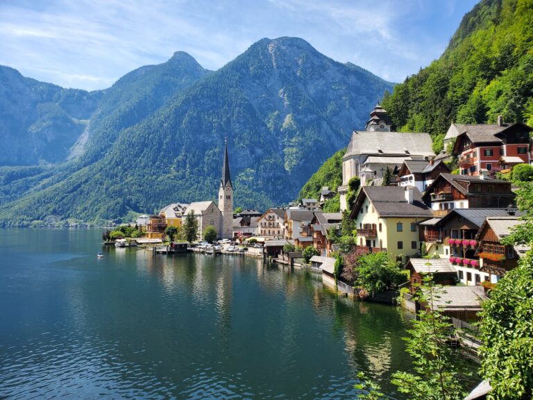 houses near body of water and mountain during daytime